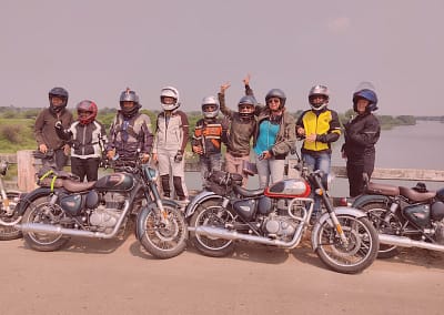 Motorcycle tour riders in India posing on the bridge