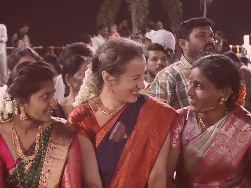 Indian women and Alison smiling Women cheering on motorcycles in the mountains